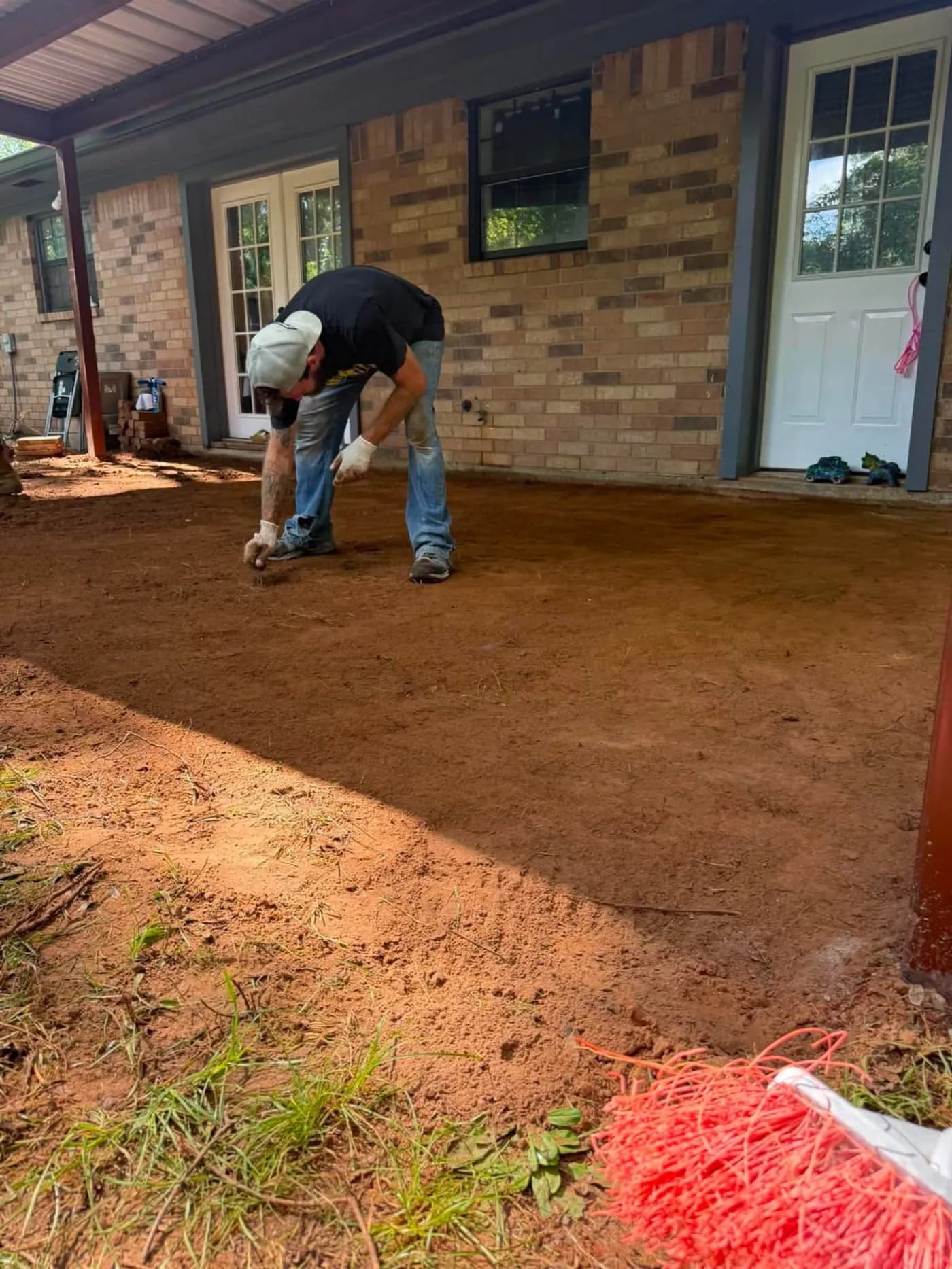 Bare graded dirt under a porch awning
