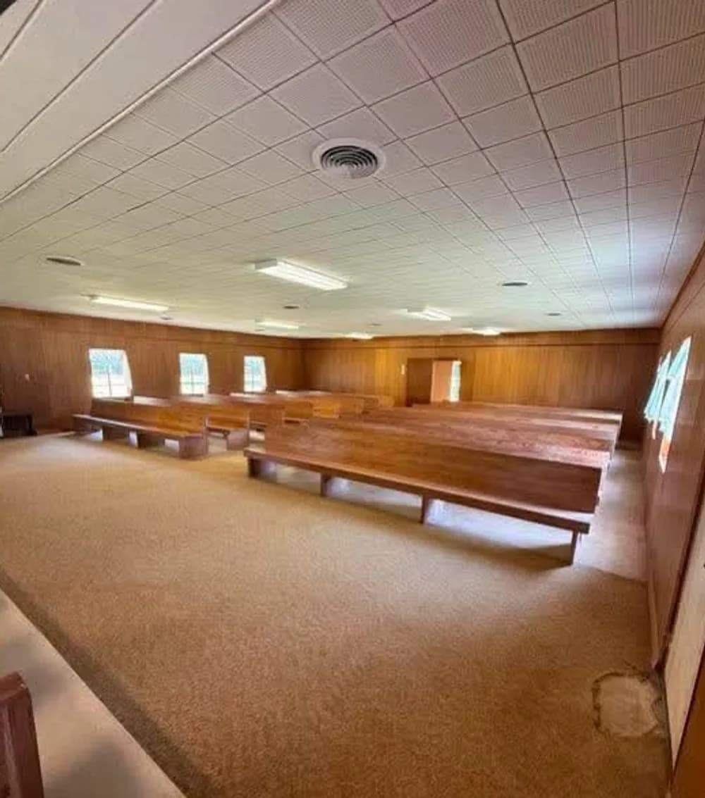 Sanctuary before: pews stacked together on worn carpet